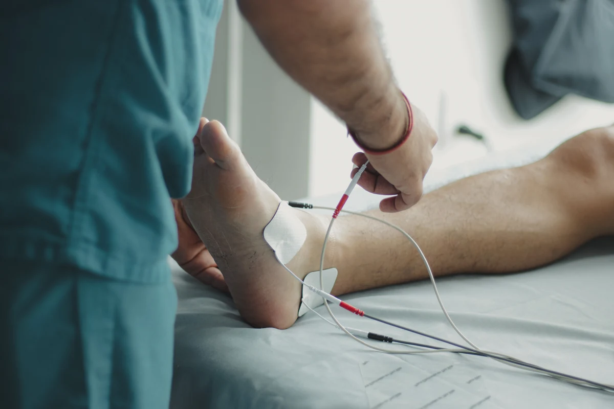 A clinician examines a patient’s foot during an in-office diagnostic assessment.