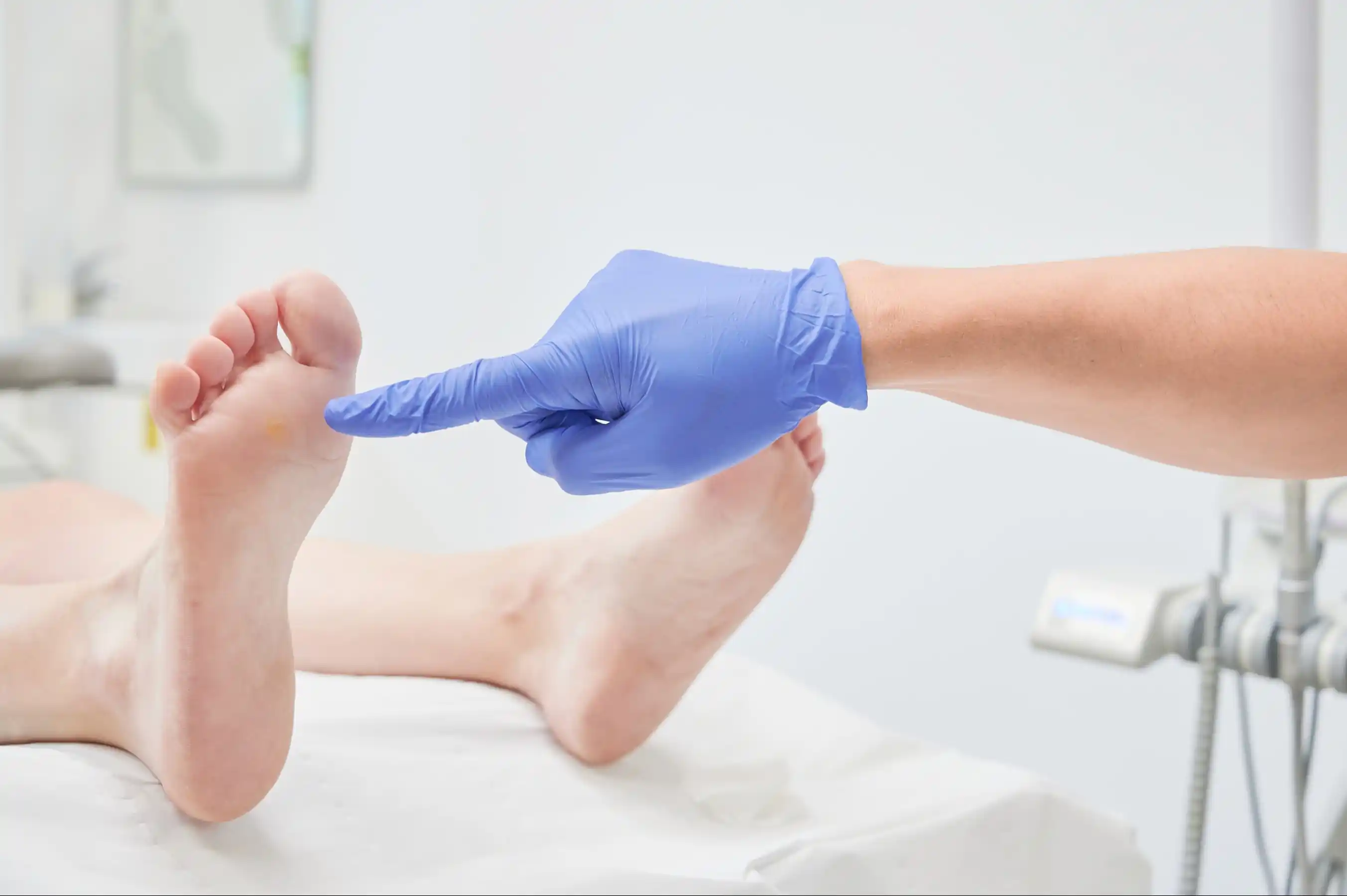 Chiropodist doctor points the foot of a patient